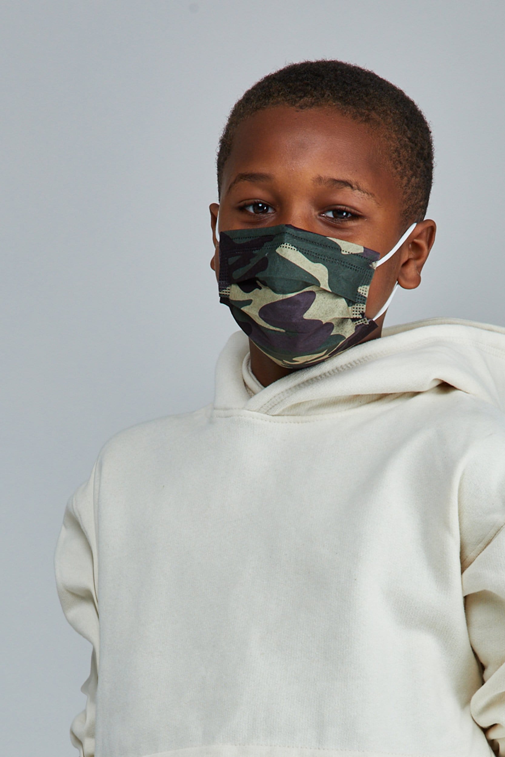 Child wearing stylish Green Camo Pleated face mask, with three layers & high quality breathable fabric. 