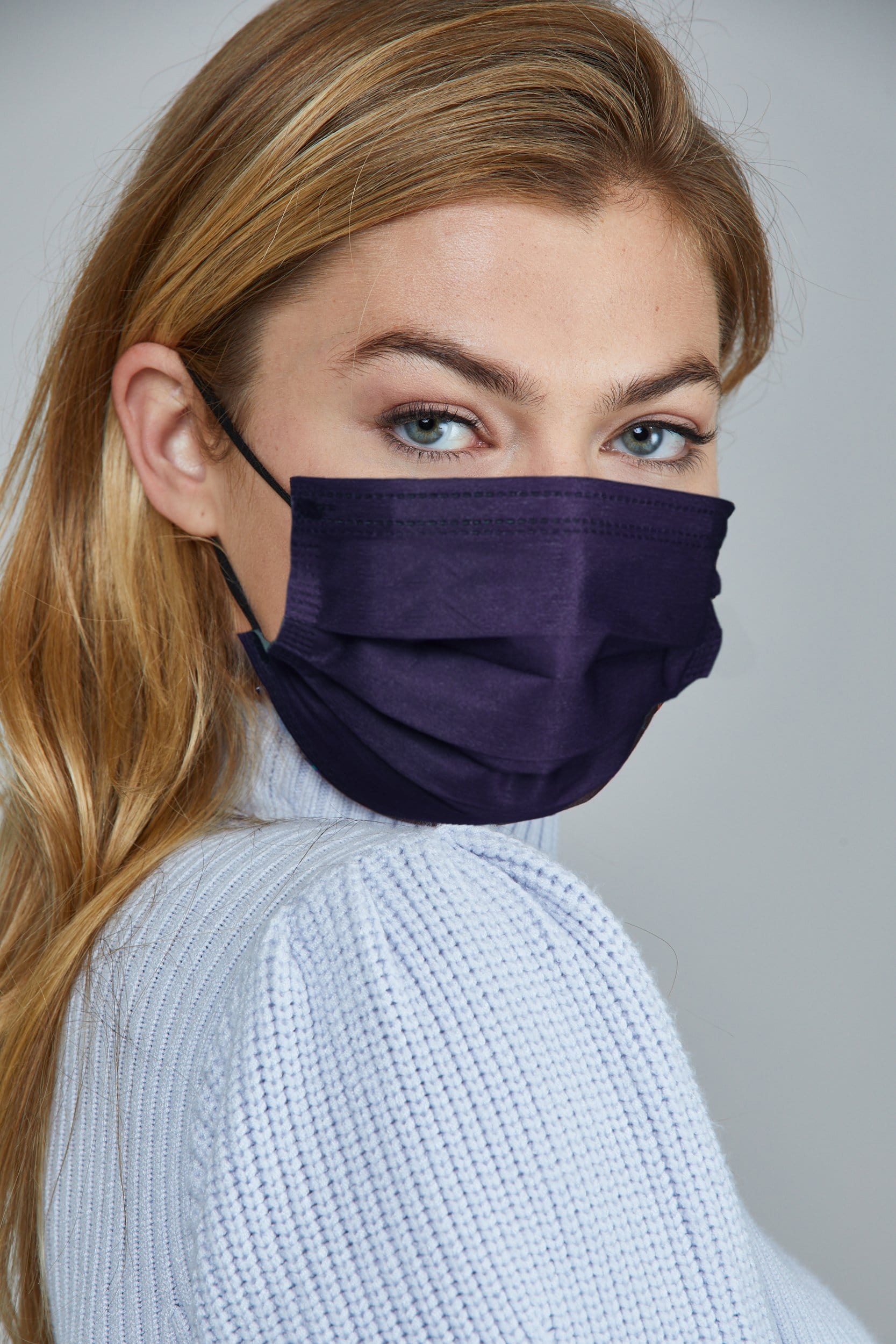 Woman wearing stylish Dark Blue Pleated face mask, with three layers & high quality breathable fabric. 