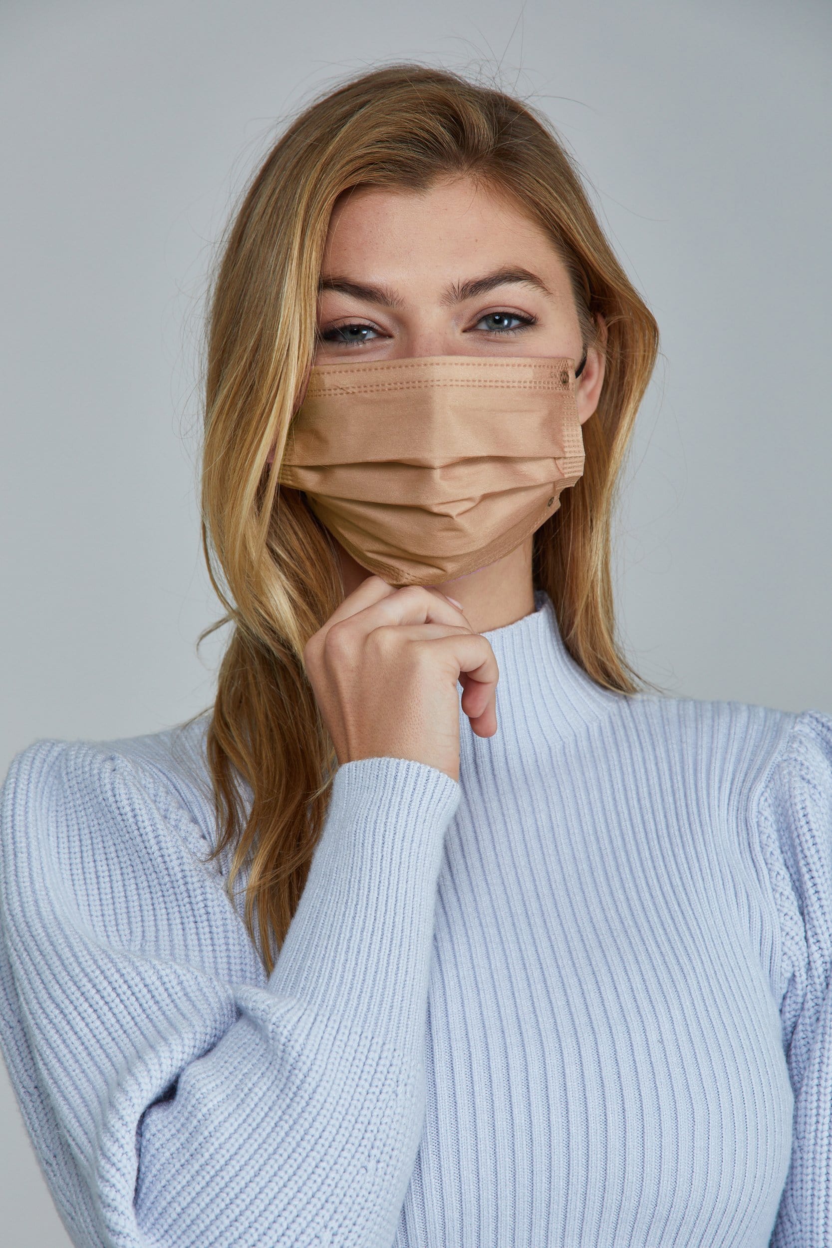 Woman wearing stylish Natural Pleated face mask, with high quality breathable fabric. 