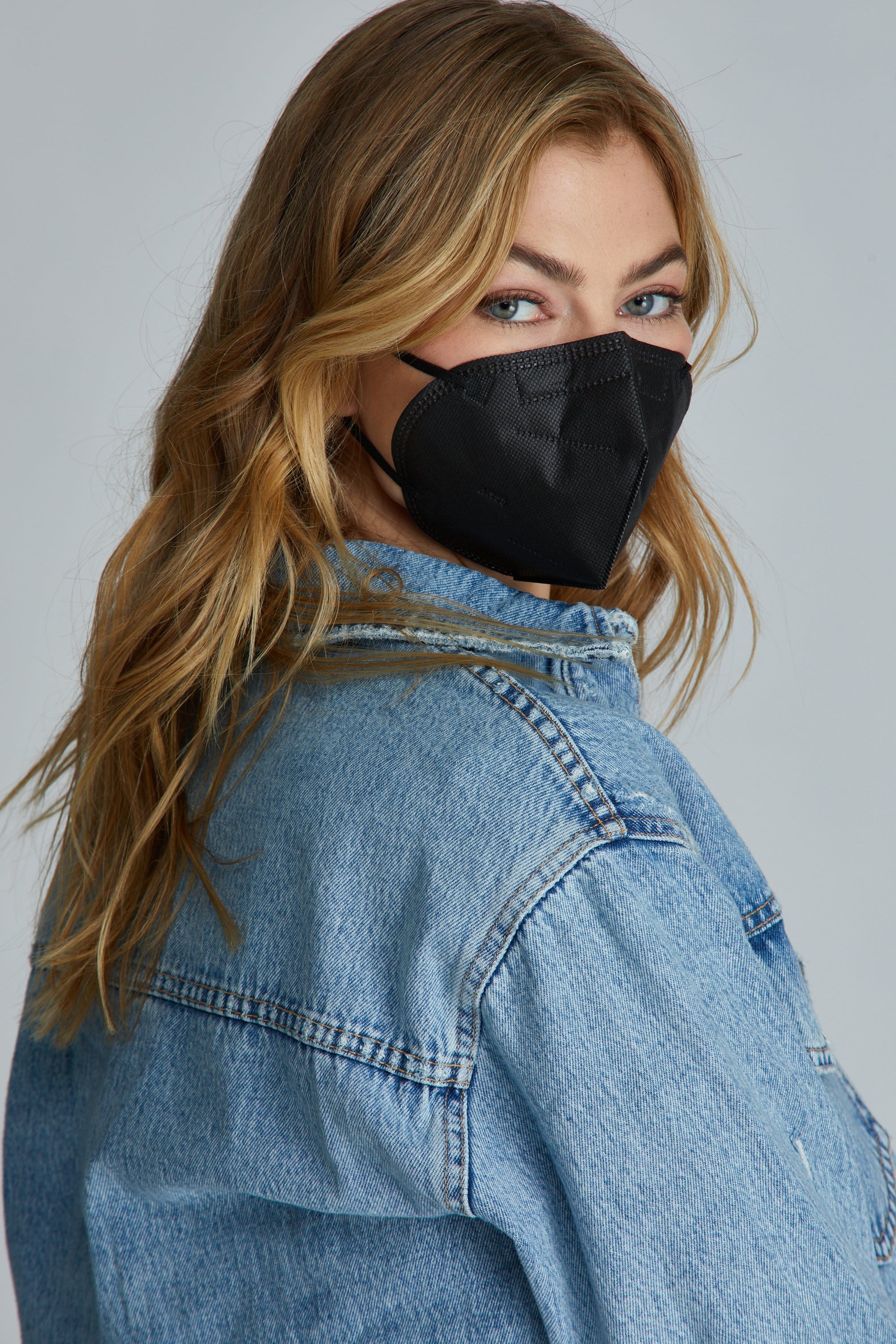 Woman wearing Black KN95 face mask, with high quality breathable fabric.  