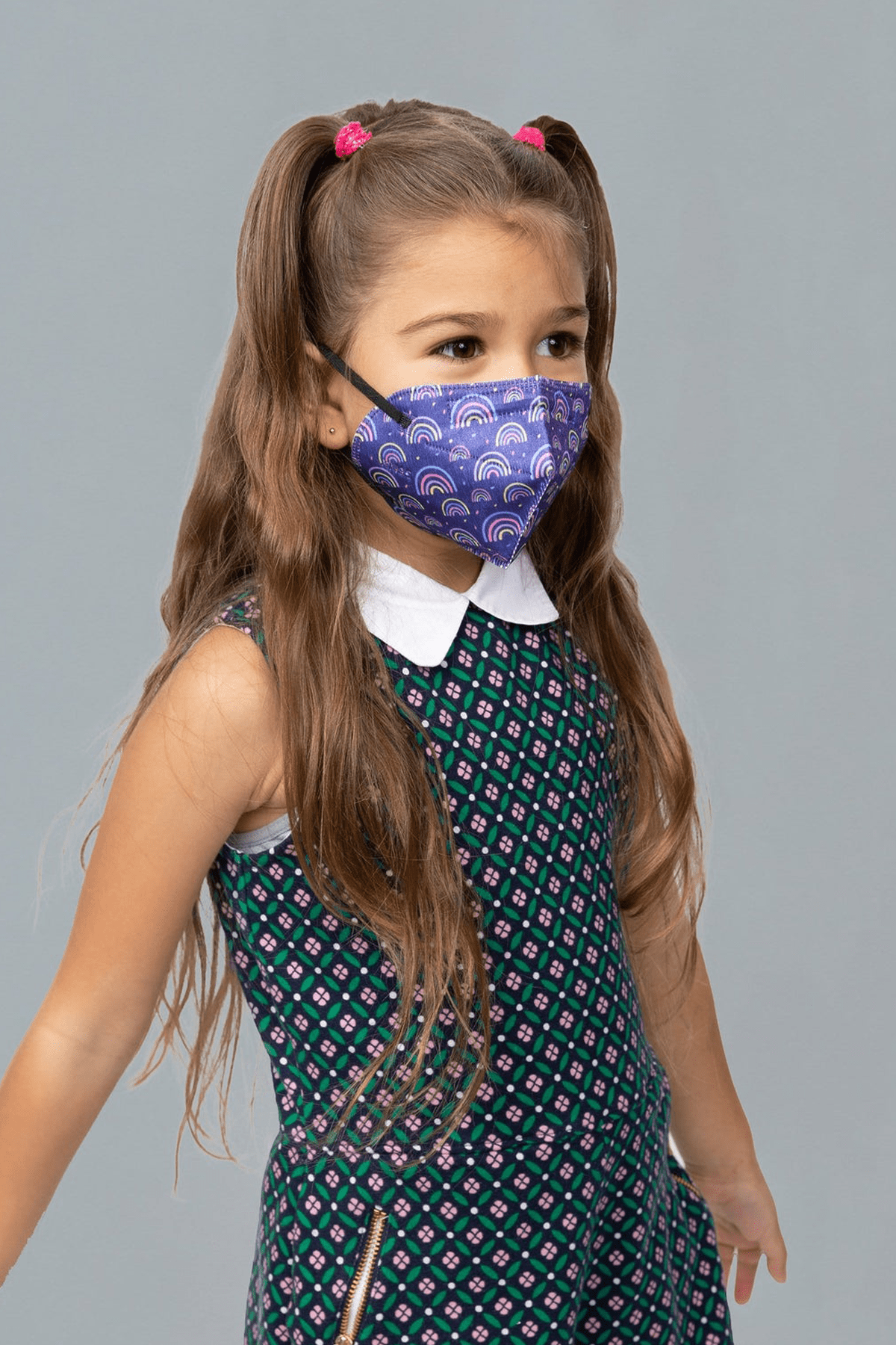 Child wearing stylish kid sized Rainbow Printed Blue KN95 face mask, with high quality breathable fabric. 