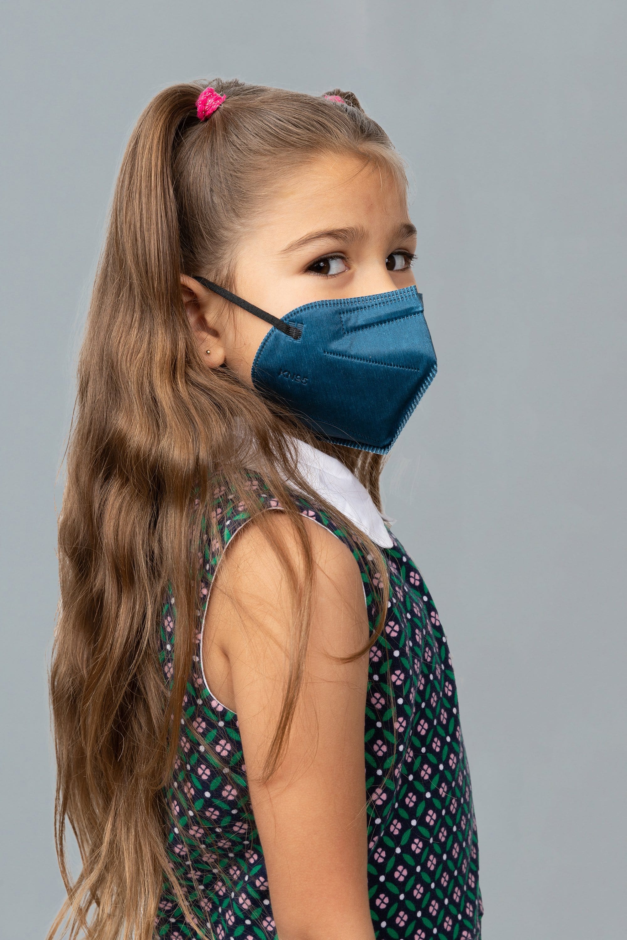 Child wearing stylish kid sized Navy Blue KN95 face mask, with high quality breathable fabric. 
