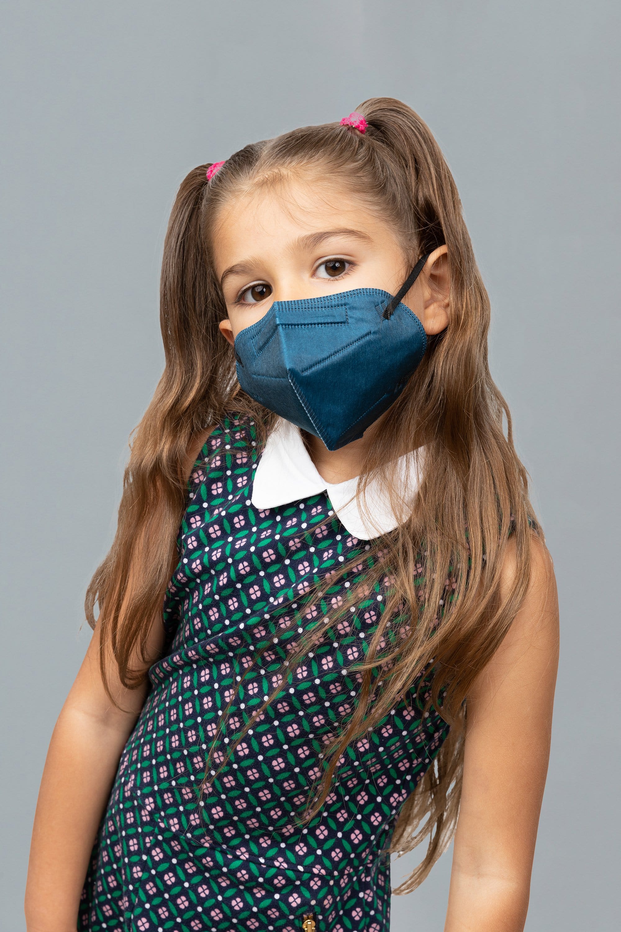 Child wearing stylish kid sized Navy Blue KN95 face mask, with high quality breathable fabric. 